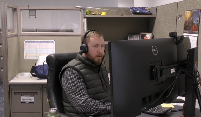 Curbell employee sitting at their desk with headset on